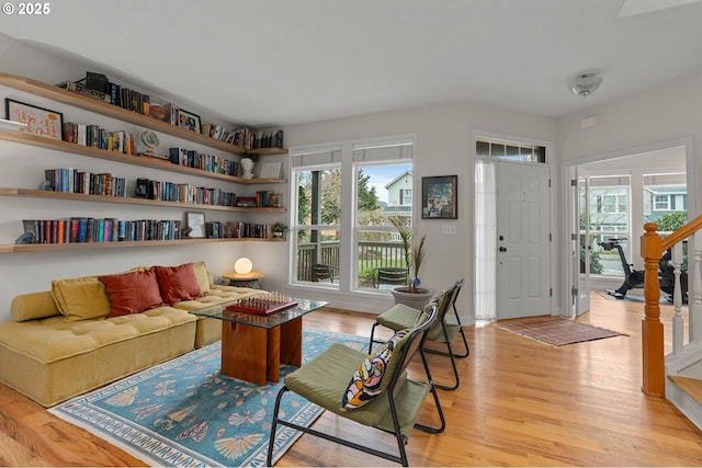 living room with a healthy amount of sunlight, stairs, and light wood finished floors