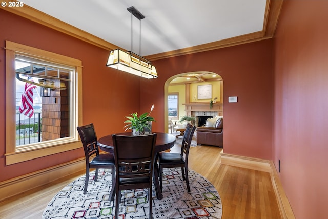 7506 SE Evergreen Hwy, Vancouver, WA 98664 - dining space featuring arched walkways, wood finished floors, a tiled fireplace, and crown molding