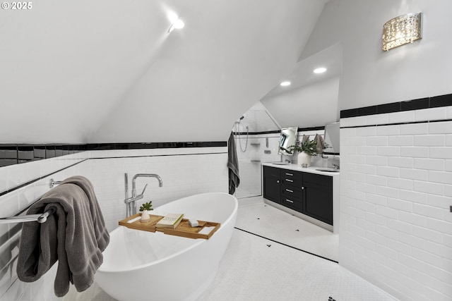 7506 SE Evergreen Hwy, Vancouver, WA 98664 - bathroom with tile walls, vaulted ceiling, vanity, a freestanding bath, and a wainscoted wall