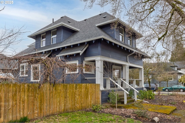 view of front of home with fence and a shingled roof