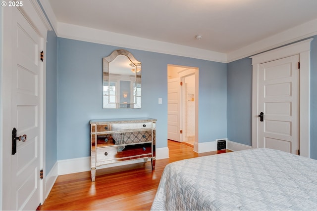 bedroom featuring baseboards and wood finished floors