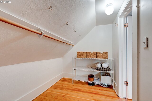 spacious closet with wood finished floors and vaulted ceiling