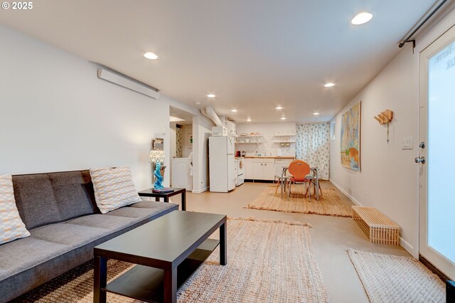 living area with recessed lighting, a wall mounted air conditioner, and baseboards