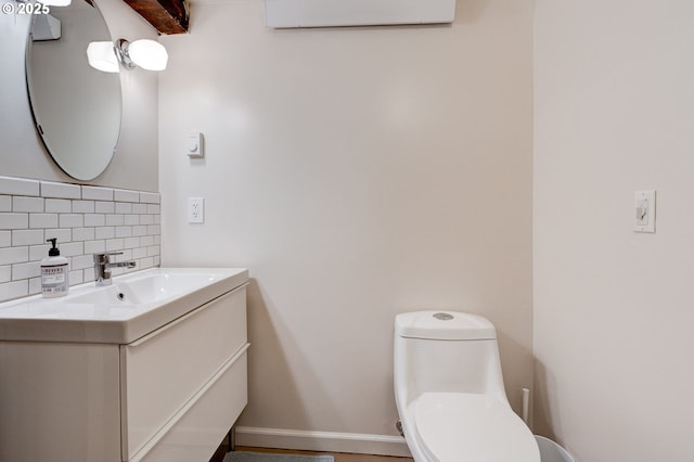 bathroom featuring toilet, an AC wall unit, backsplash, baseboards, and vanity