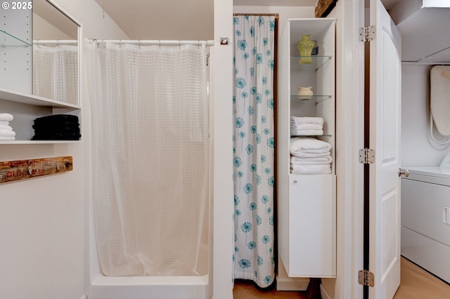 bathroom with washer / dryer and a shower with curtain