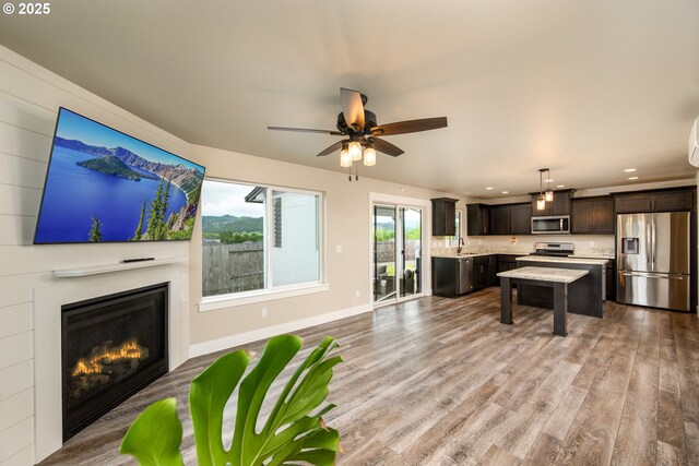 625 Brady Ln, Roseburg, OR 97471 - living room with light wood-style floors, ceiling fan, recessed lighting, a glass covered fireplace, and baseboards