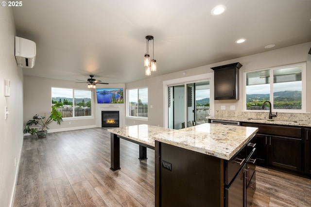625 Brady Ln, Roseburg, OR 97471 - kitchen featuring a sink, a wall unit AC, ceiling fan, open floor plan, and a glass covered fireplace