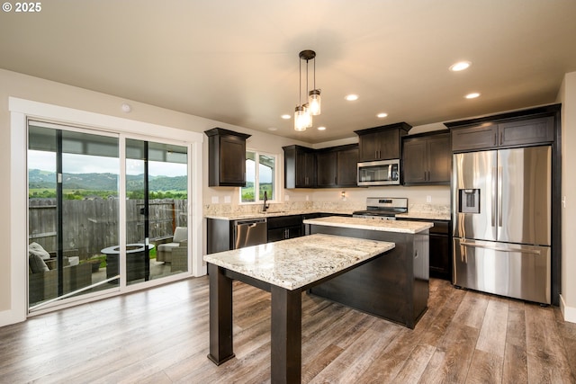 625 Brady Ln, Roseburg, OR 97471 - kitchen featuring appliances with stainless steel finishes, dark brown cabinets, recessed lighting, wood finished floors, and pendant lighting
