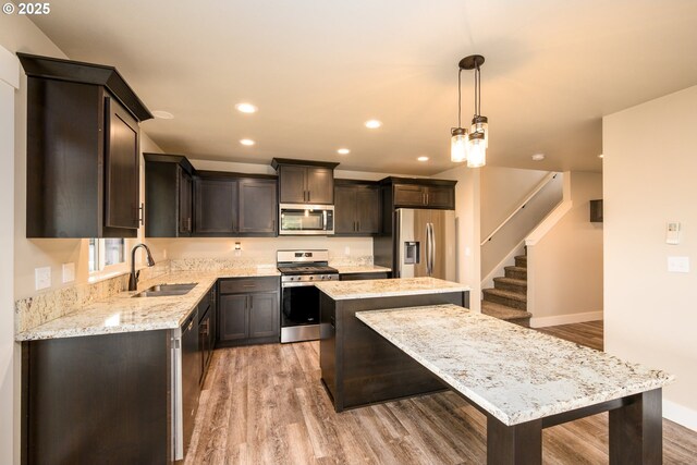 625 Brady Ln, Roseburg, OR 97471 - kitchen featuring appliances with stainless steel finishes, a sink, a kitchen island, light wood finished floors, and recessed lighting