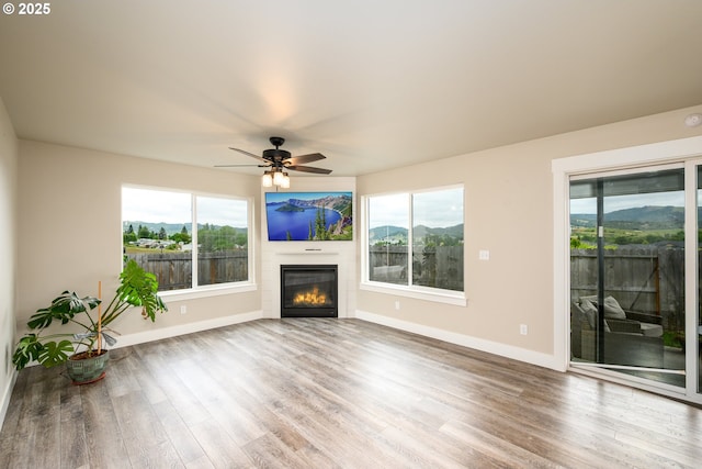 625 Brady Ln, Roseburg, OR 97471 - unfurnished living room featuring wood finished floors, plenty of natural light, baseboards, and ceiling fan
