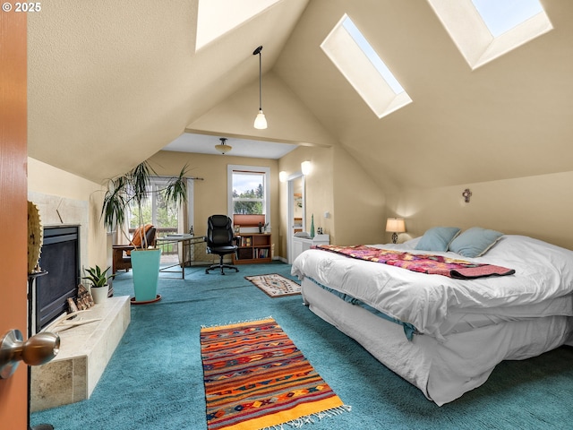 carpeted bedroom featuring a premium fireplace and vaulted ceiling with skylight