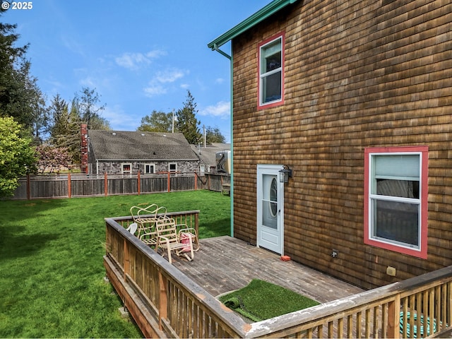wooden terrace featuring fence and a yard