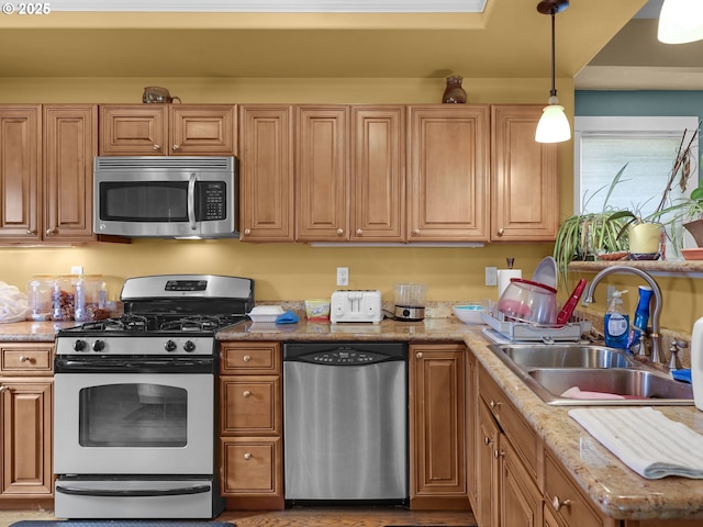 kitchen featuring a sink, pendant lighting, and stainless steel appliances