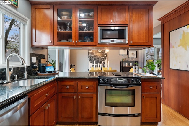 kitchen featuring tasteful backsplash, stainless steel appliances, sink, and dark stone countertops