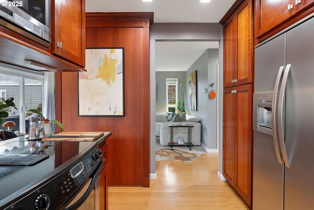 kitchen with light hardwood / wood-style floors and appliances with stainless steel finishes