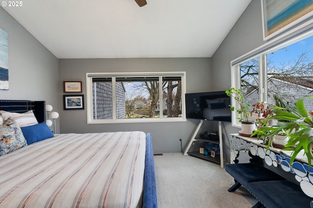 bedroom with multiple windows, vaulted ceiling, and light colored carpet