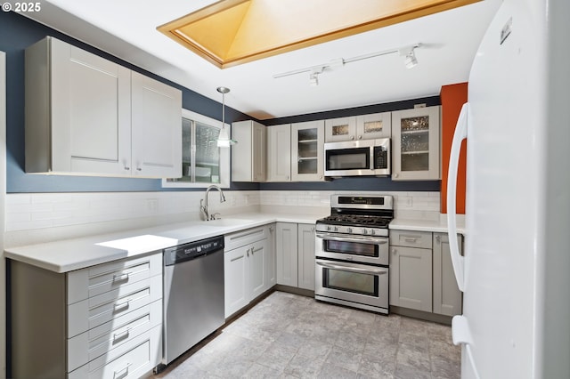 5425 SW Willow Ave, Corvallis, OR 97333 - kitchen with stainless steel appliances, tasteful backsplash, glass insert cabinets, and gray cabinetry