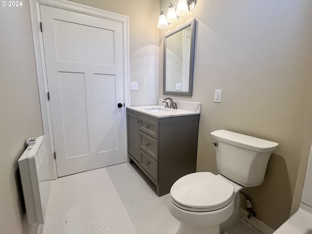 bathroom with tile patterned flooring, vanity, toilet, and radiator heating unit