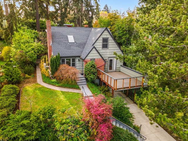 2362 Charnelton St, Eugene, OR 97405 - tudor-style house featuring a chimney, roof with shingles, a wooden deck, and view of wooded area