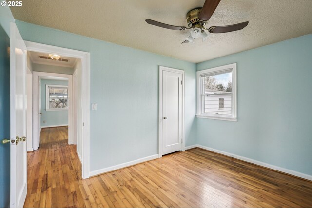 7515 SE Luther Rd, Portland, OR 97206 - unfurnished bedroom with light wood-style floors, baseboards, a textured ceiling, a closet, and a ceiling fan