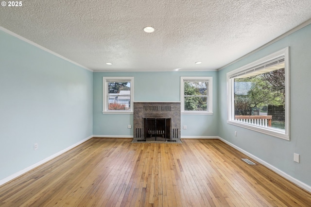 7515 SE Luther Rd, Portland, OR 97206 - unfurnished living room featuring hardwood / wood-style flooring, ornamental molding, a textured ceiling, baseboards, and a brick fireplace