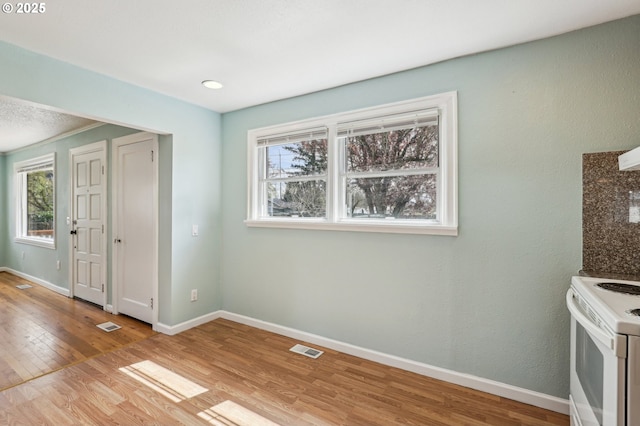 7515 SE Luther Rd, Portland, OR 97206 - unfurnished dining area featuring light wood-style floors, baseboards, and healthy amount of natural light