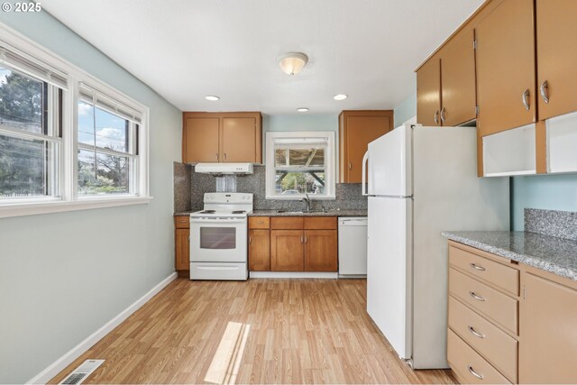 7515 SE Luther Rd, Portland, OR 97206 - kitchen featuring white appliances, under cabinet range hood, light wood finished floors, tasteful backsplash, and a sink