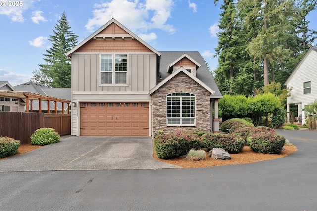 14386 NW Tripton Ct, Beaverton, OR 97006 - craftsman-style house with board and batten siding, stone siding, a garage, and asphalt driveway