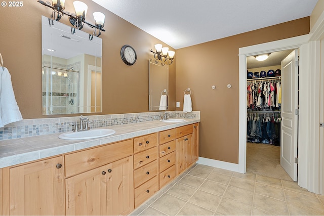 14386 NW Tripton Ct, Beaverton, OR 97006 - full bathroom with a stall shower, double vanity, tile patterned flooring, decorative backsplash, and a walk in closet
