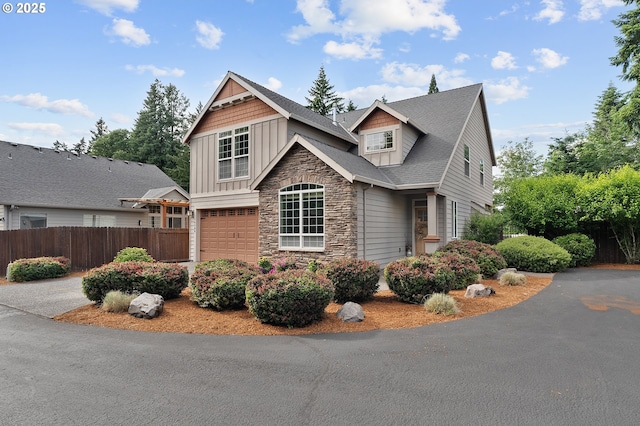 14386 NW Tripton Ct, Beaverton, OR 97006 - view of front of home featuring stone siding, board and batten siding, a garage, and a shingled roof