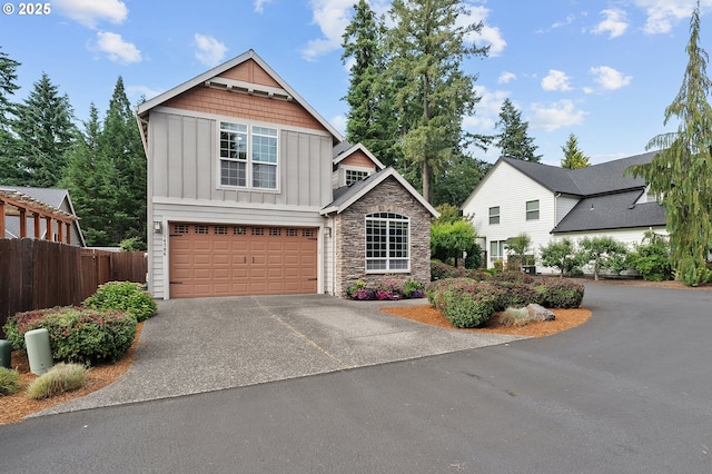 14386 NW Tripton Ct, Beaverton, OR 97006 - view of front facade with board and batten siding, asphalt driveway, stone siding, and a garage