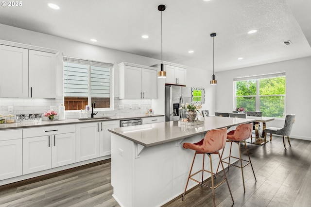 837 S 26th Ave, Cornelius, OR 97113 - kitchen featuring stainless steel appliances, recessed lighting, wood finished floors, tasteful backsplash, and a breakfast bar area
