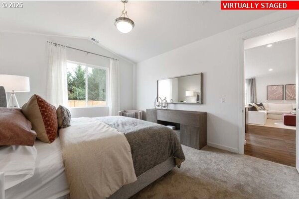 bedroom with lofted ceiling, carpet, and baseboards