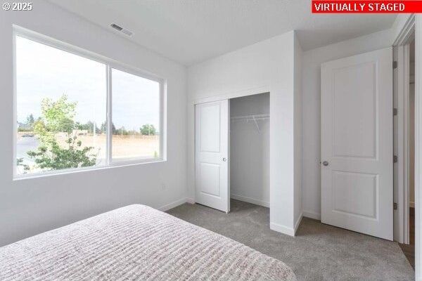 carpeted bedroom featuring a closet and baseboards