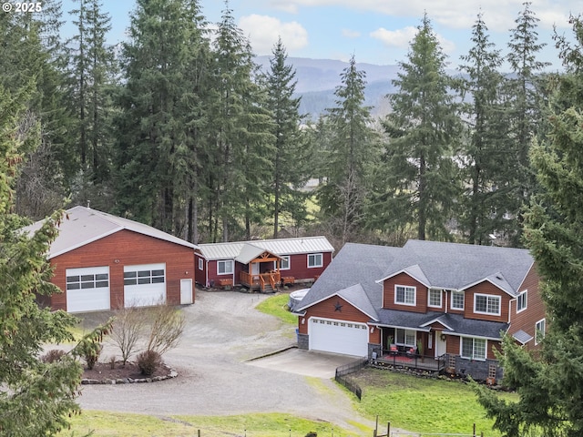 view of front of house featuring a front yard, covered porch, roof with shingles, and driveway