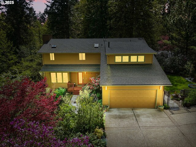view of front of property with fence, a shingled roof, a garage, a gate, and driveway