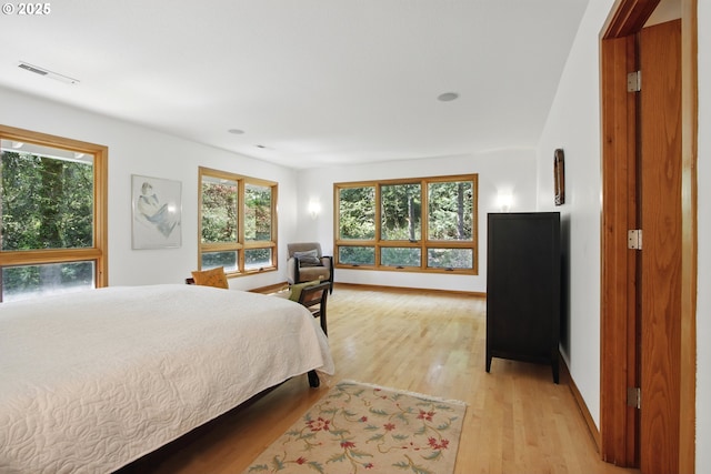 bedroom with light wood-style floors, baseboards, and visible vents