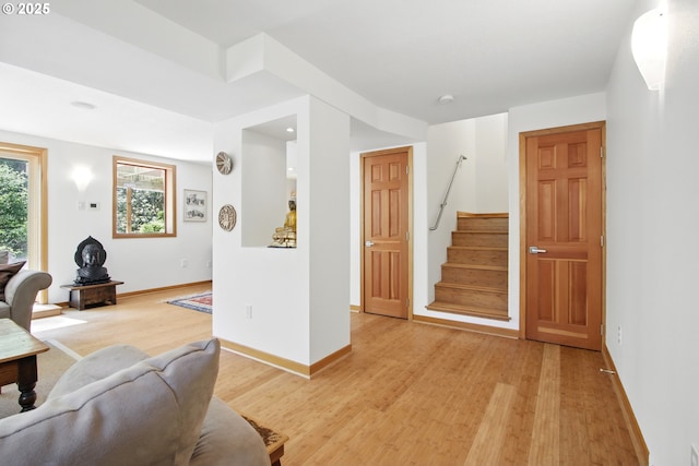 living room with stairs, baseboards, and light wood finished floors