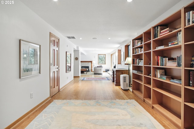 corridor with recessed lighting, baseboards, light wood finished floors, and visible vents
