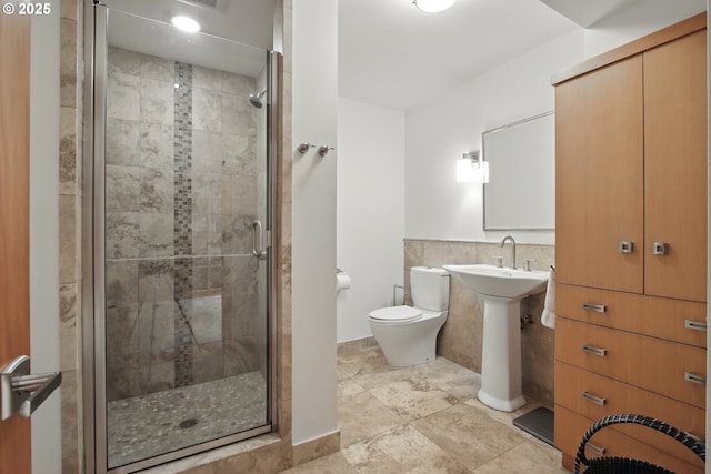 full bath with toilet, tile walls, and a stall shower