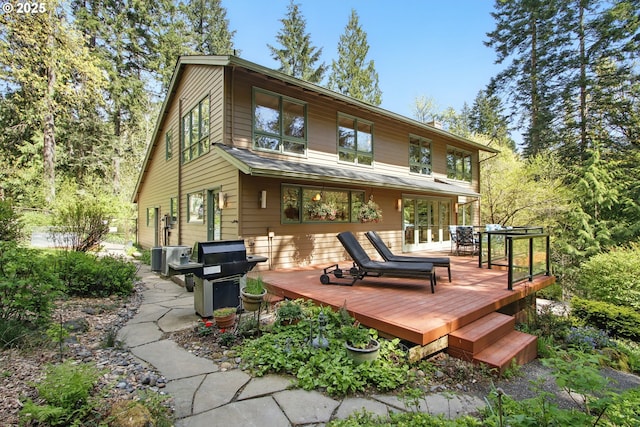 rear view of house featuring a wooden deck
