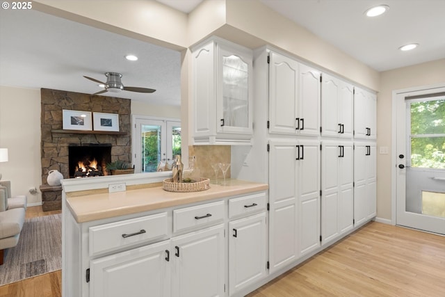 2395 SW Timberline Dr, Portland, OR 97225 - kitchen featuring ceiling fan, light wood-style flooring, open floor plan, white cabinets, and recessed lighting