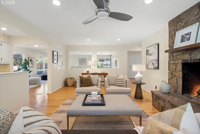 2395 SW Timberline Dr, Portland, OR 97225 - living room with a stone fireplace, light wood-style floors, a ceiling fan, recessed lighting, and baseboards