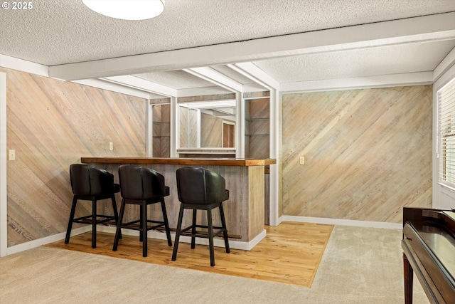 2395 SW Timberline Dr, Portland, OR 97225 - indoor dry bar featuring wood walls, baseboards, a textured ceiling, and carpet flooring