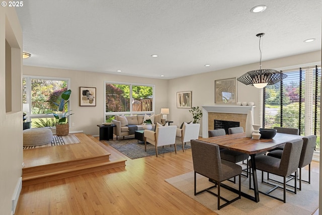 2395 SW Timberline Dr, Portland, OR 97225 - dining room with light wood-style floors, a fireplace, recessed lighting, and a textured ceiling