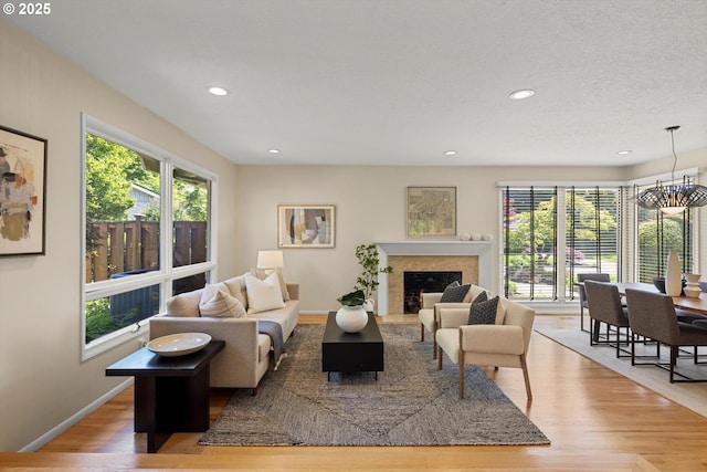2395 SW Timberline Dr, Portland, OR 97225 - living area with plenty of natural light, a fireplace, light wood finished floors, recessed lighting, and baseboards