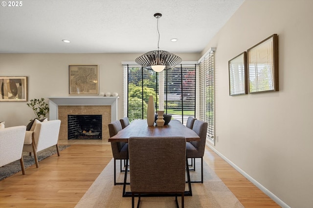 2395 SW Timberline Dr, Portland, OR 97225 - dining space with light wood-style floors, recessed lighting, a fireplace with flush hearth, baseboards, and a textured ceiling