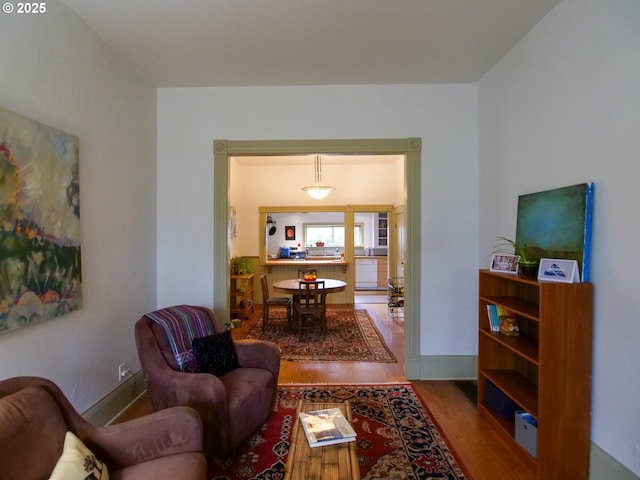 living area featuring baseboards and wood finished floors