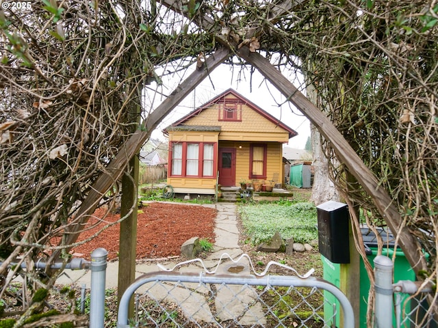 view of front of property with a shingled roof and fence