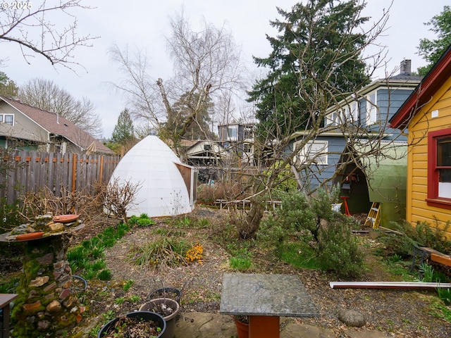 view of yard featuring an outdoor structure, fence, and a shed